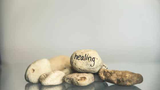 Smooth stones stacked together with the word healing written on the top stone